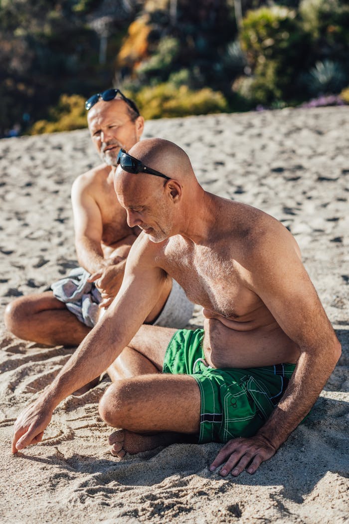 A senior couple sitting together on a sunny beach, enjoying leisure time in summer.